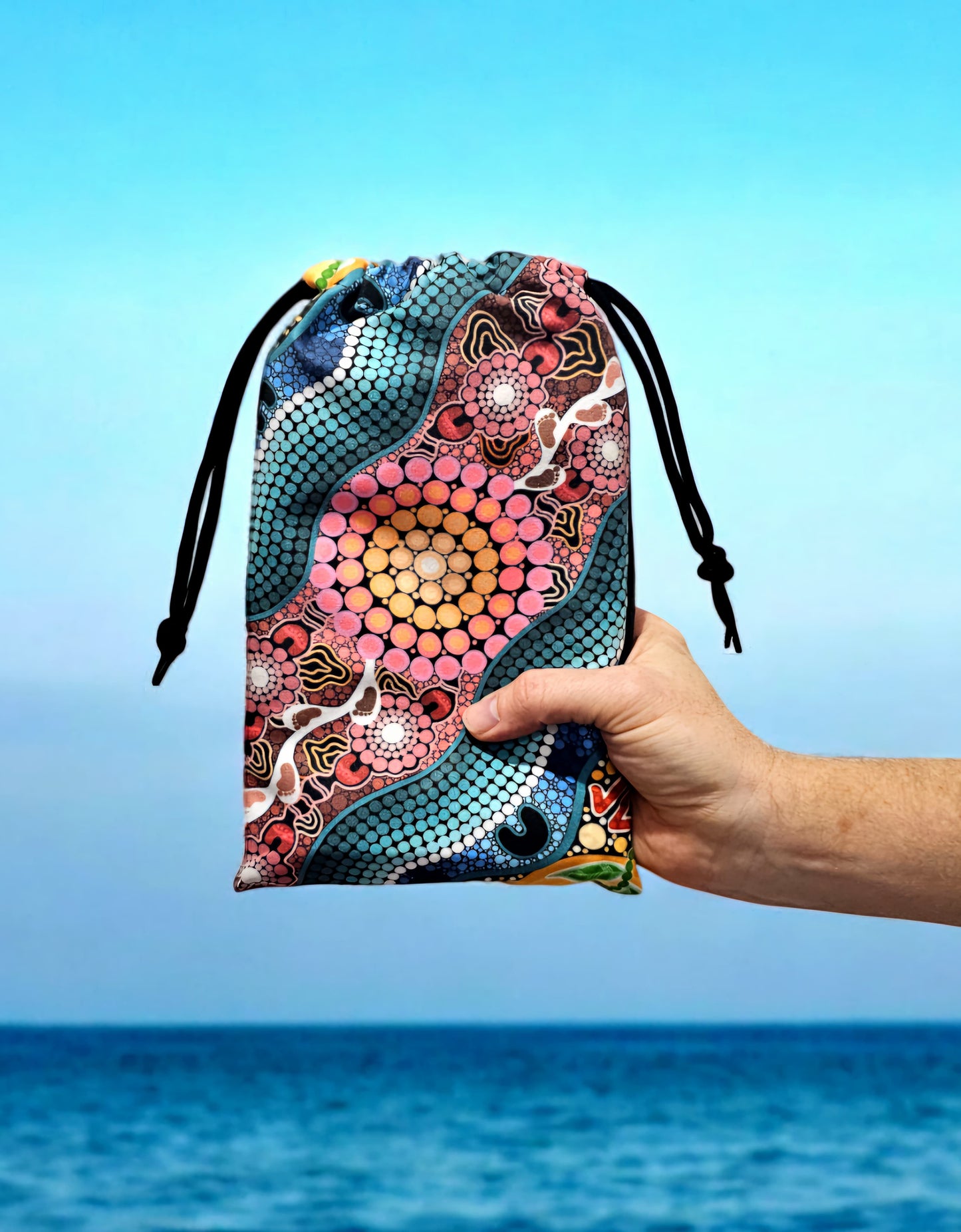 A Breath of Fresh Air Indigenous Travel Towel folded in eco-friendly travel bag, showcasing the Aboriginal artwork with breath symbols and traditional patterns that connect users to the sacred air element and spiritual cleansing in ancestral stories