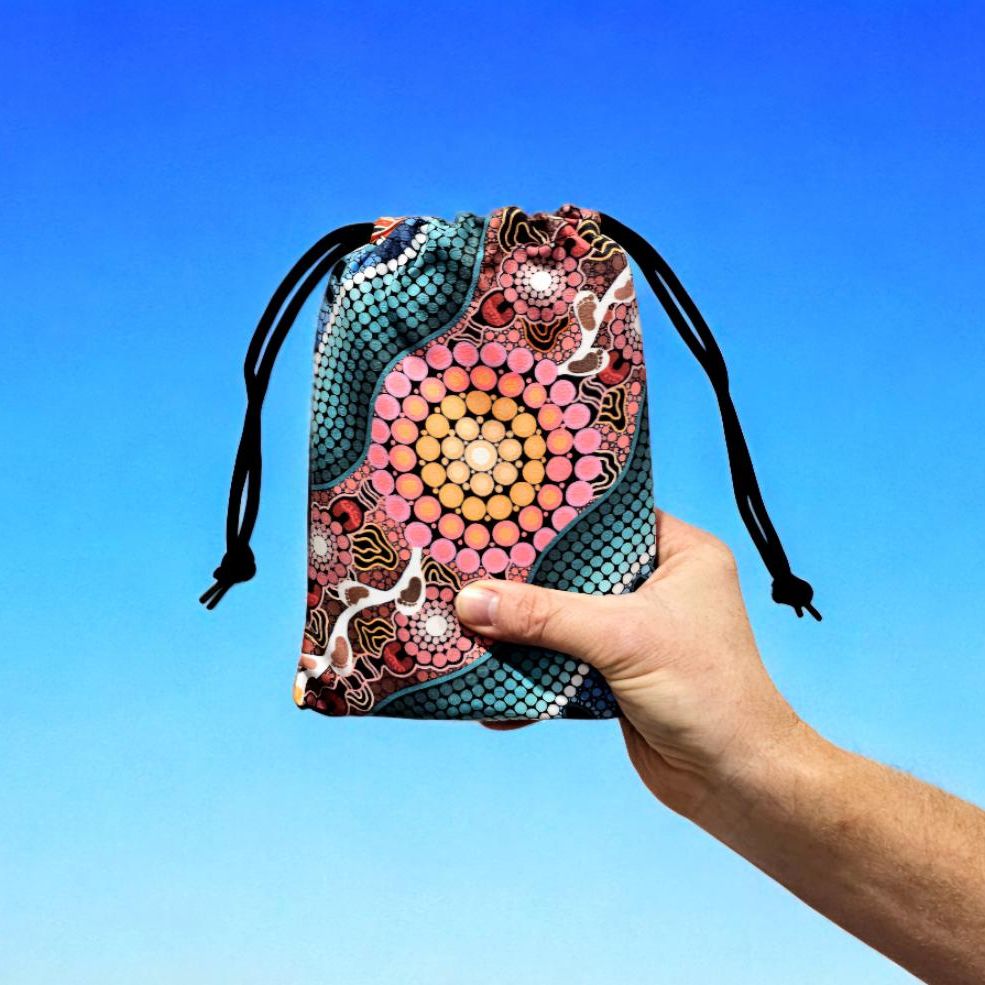 A Breath of Fresh Air Kids Indigenous Travel Towel folded in compact travel bag, showcasing the Aboriginal artwork with breath symbols and traditional patterns that connect young ones to the sacred air element and spiritual cleansing in ancestral stories