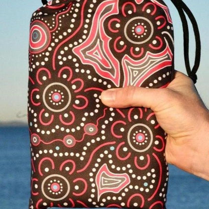 Frangipani Indigenous Travel Towel folded in compact travel bag, showcasing the Aboriginal artwork with frangipani symbols and traditional patterns that connect travelers to the sacred beauty and spiritual essence of native flowering plants
