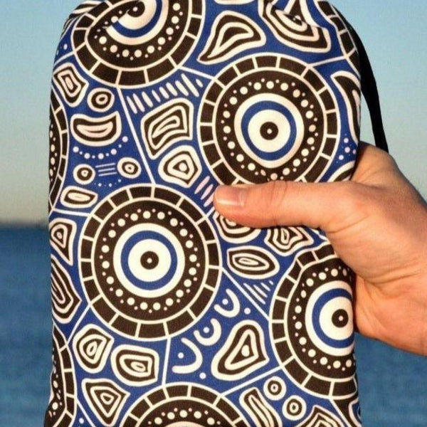 Seascape Indigenous Travel Towel folded in eco-friendly packaging, showcasing Aboriginal ocean dreamtime artwork with flowing water patterns and traditional dot work representing the spiritual connection to country and sea
